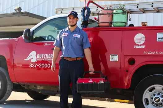 image of a Butcher AC technician in front of company truck