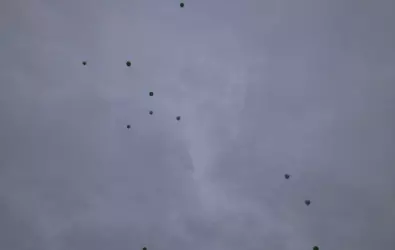 green balloons against a dark gray sky