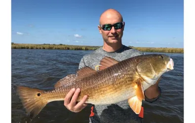 a Butcher AC team member with a fresh caught fish