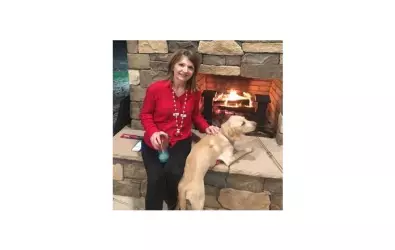 photo of woman and a dog in front of a fire place