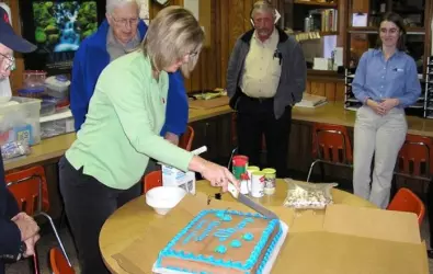 Photo of a woman cutting a cake