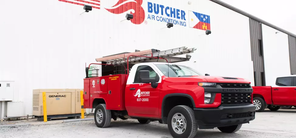 Image of a Butcher AC company truck in front of the company building