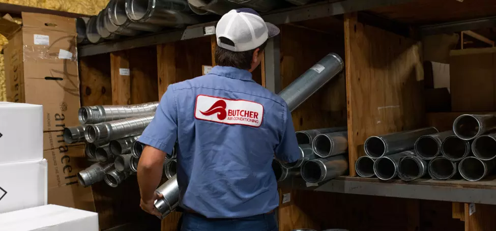 Image of a Butcher Air Conditioning technician putting air ducts into inventory