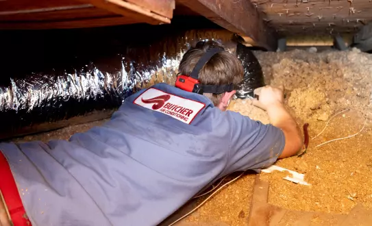 Image of a Butcher Air Conditioning technician installing ductwork in a home.