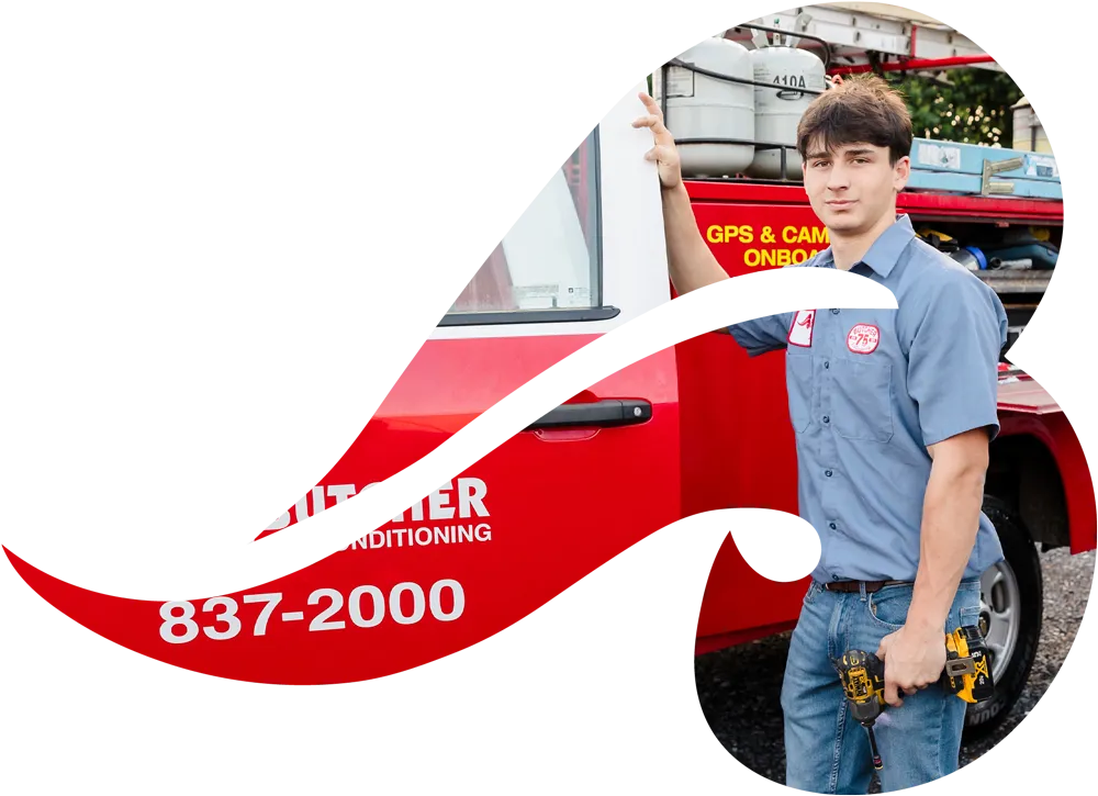 a man in technician uniform standing by red service truck holding cordless drill for HVAC service