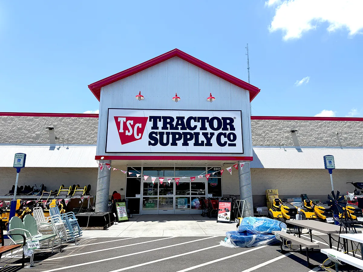 Tractor Supply Co storefront with outdoor equipment, patio furniture and yellow riding mowers displayed in front