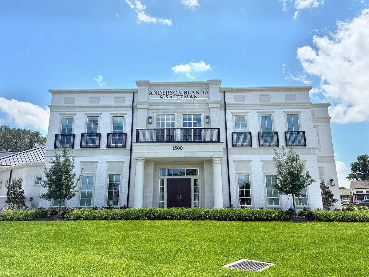 Anderson Blanda & Saltzman law office exterior, white two-story classical facade with columns, balcony and green lawn