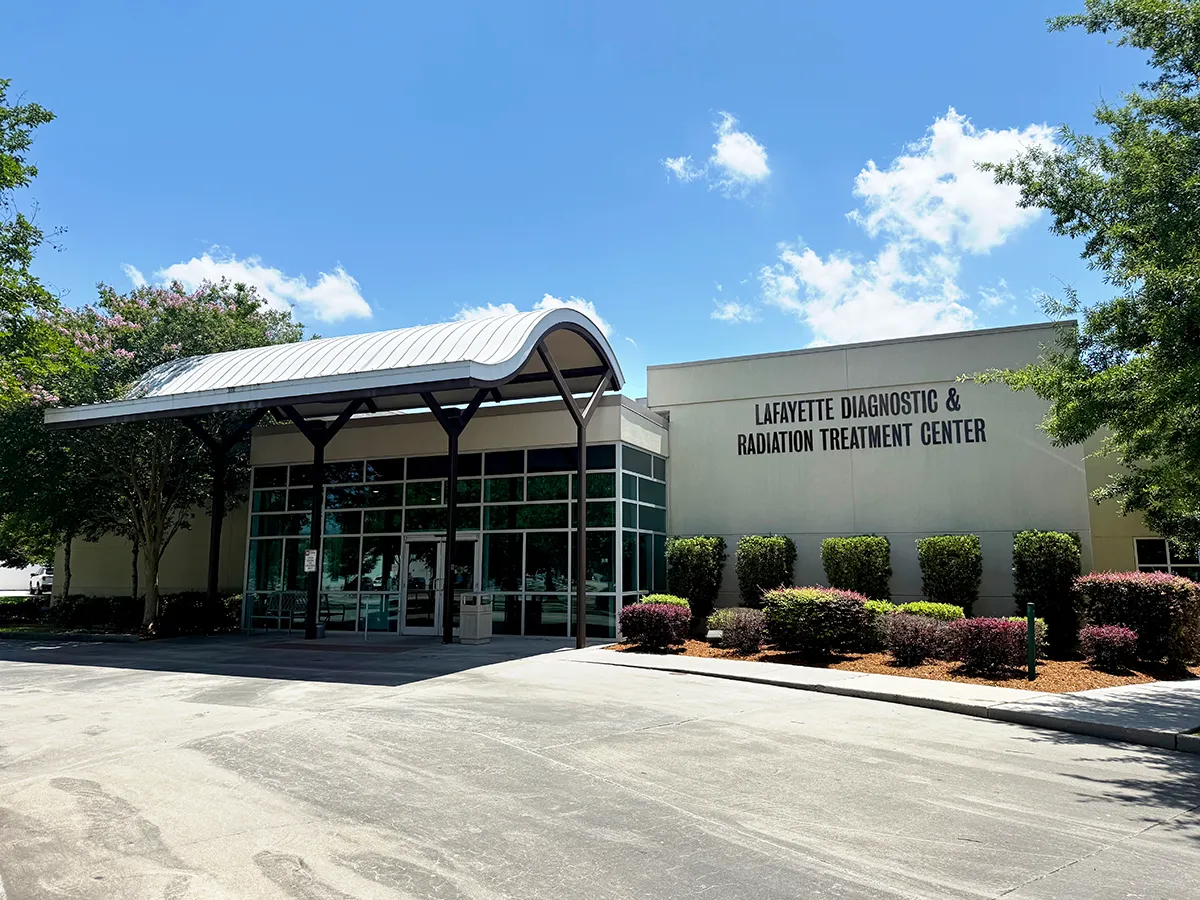 Lafayette Diagnostic & Radiation Treatment Center exterior with covered glass entrance, landscaped grounds and clear blue sky