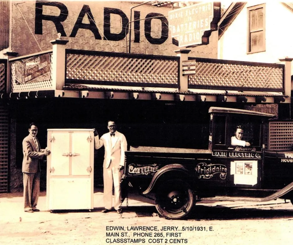 Vintage 1931 radio store facade with two men posing by a refrigerator and Frigidaire delivery truck