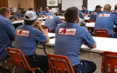 Butcher Air Conditioning technicians in blue uniforms attending team training in a classroom